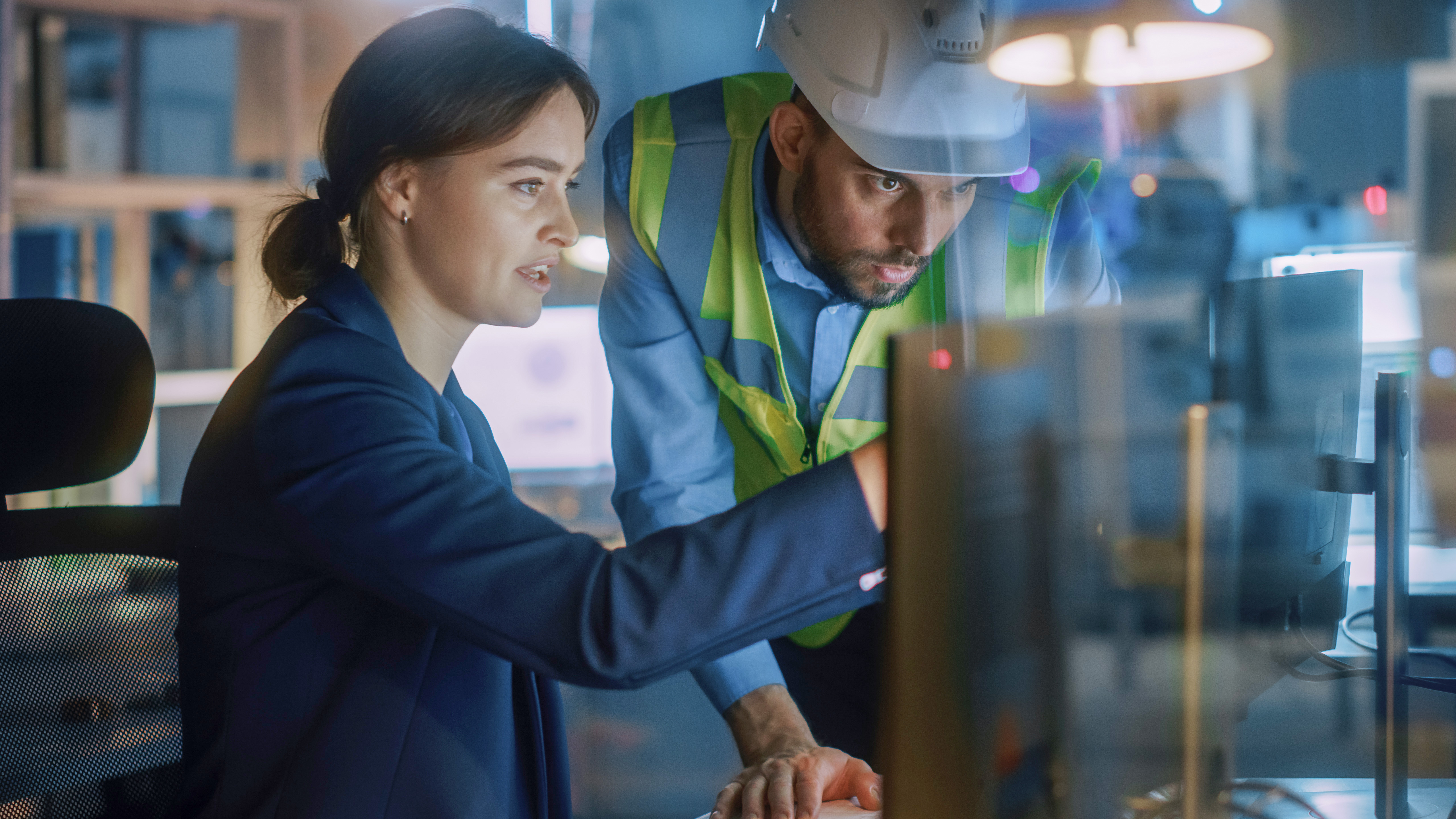 Modern Factory Office_ Male Project Manager Talks to a Female Industrial Engineer who Works on Computer. Professional Teamwork, Specialists Solving Problems, Finding Solutions